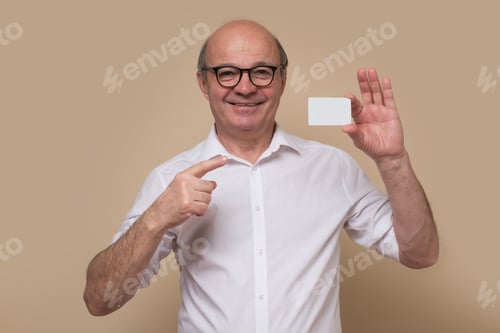 Preview: Satisfied senior man holding and showing blank card ready for your text
