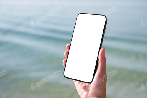 Preview: Mockup image of a woman holding mobile phone with blank desktop screen by the sea