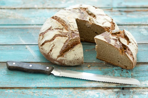 Preview: Rustic rye bread on blue wood, knife