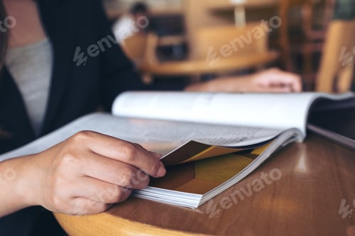 Preview: Closeup image of a business woman reading a book in modern cafe
