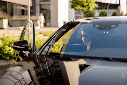 Preview: Businessman with laptop in car