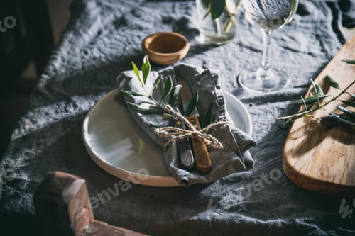 Preview: Table setting with white plate, linen napkin, olive brunch Trendy rustic table setting.
