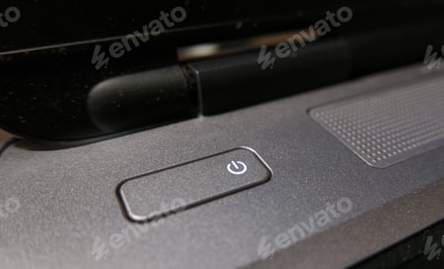 Preview: Close-up image of power switch button on gray laptop.