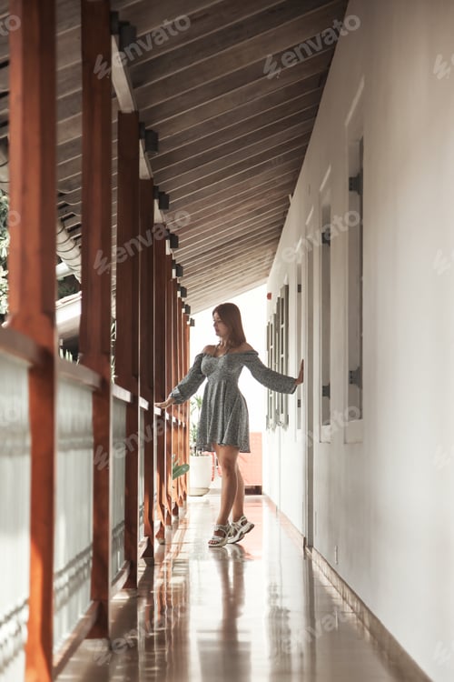 Preview: A woman in summer casual clothes on the territory of an old hotel