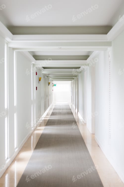 Preview: Vertical shot of a long, white corridor with clean walls and reflective floor