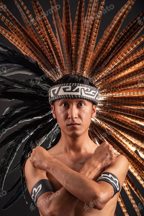 Preview: A man wearing a feathered headdress and a black bandana