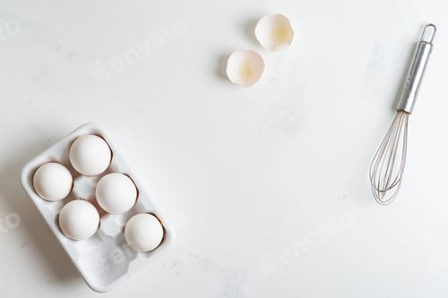 Preview: Ceramic box with natural organic farm eggs and metal whisk on a stone kitchen table