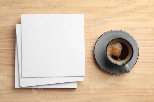 Preview: Blank paper sheets for brochure and cup of coffee on wooden background, flat lay. Mock up