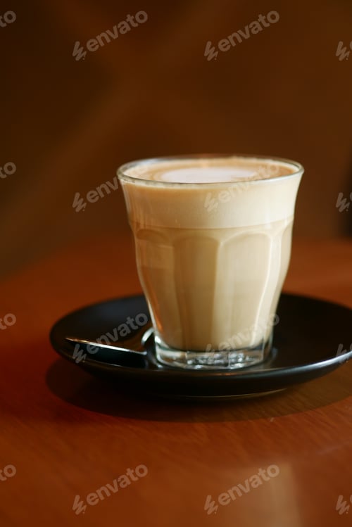 Preview: a cup of late coffee with flower shape design on top at cafe