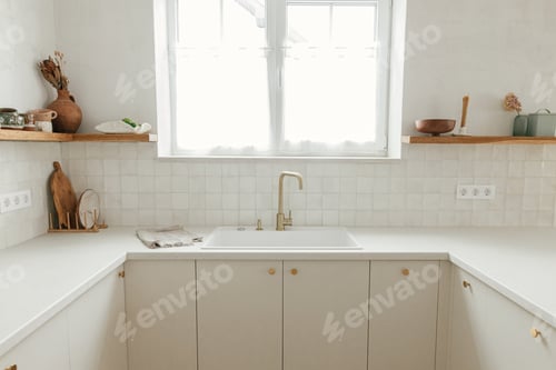 Preview: Stylish white kitchen cabinets, brass faucet and granite sink, wooden shelves with utensils