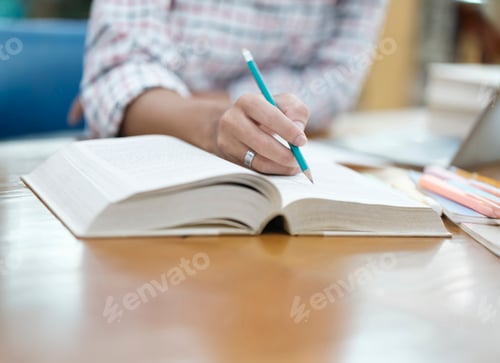 Preview: Student Taking Notes in Library with Laptop