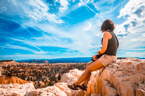 Preview: A girl sitting looking at the views from the Sunrise Point in Bryce National Park