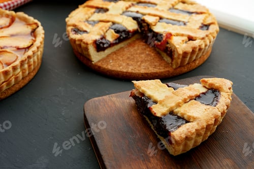 Preview: Cut slice of berry tart pie on black table