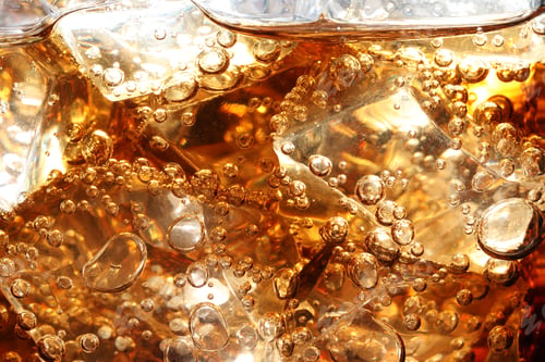 Preview: Refreshing cola with ice as background, macro view