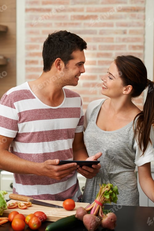 Couple Smiling and Cooking with Fresh Vegetables