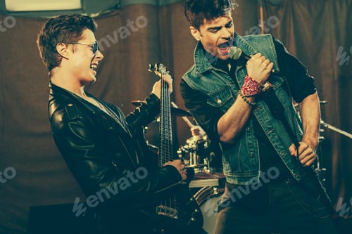Preview: handsome man singing near guitarist playing electric guitar