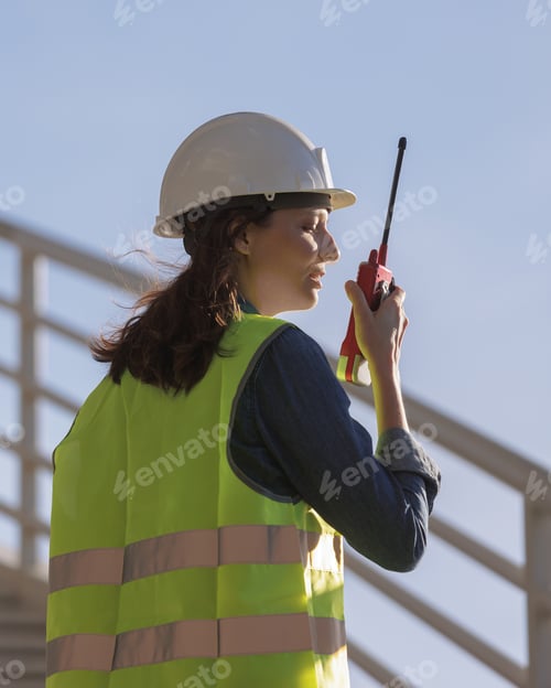 Preview: female engineer with a walkie-talkie at the construction site gives instructions. European