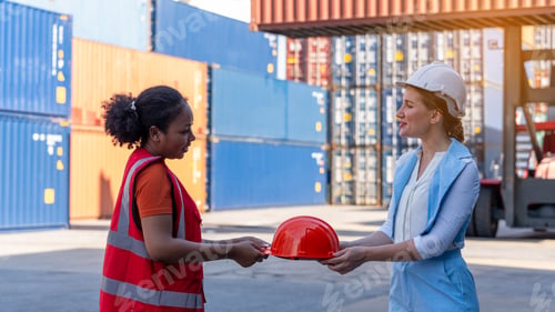 Preview: African american woman get safety helmet from Woman CEO cargo container warehouse on activity safety