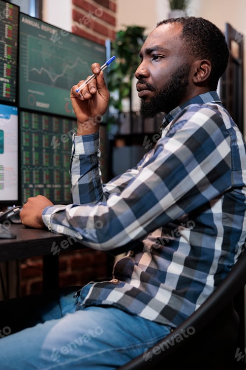 Preview: Mindful office trading agent sitting at multi monitor workstation while buying and selling stock