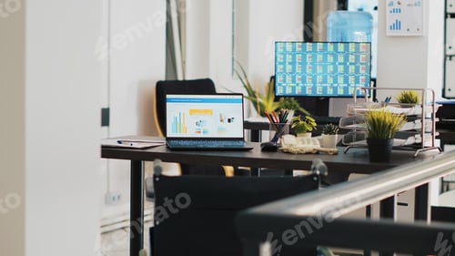 Preview: Company workspace with nobody in and business figures on computer monitors