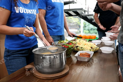 Preview: Volunteers serving food to poor people in charity centre, closeup