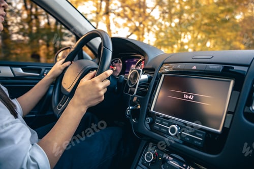 Preview: Woman driver's hands on the steering wheel inside the car.