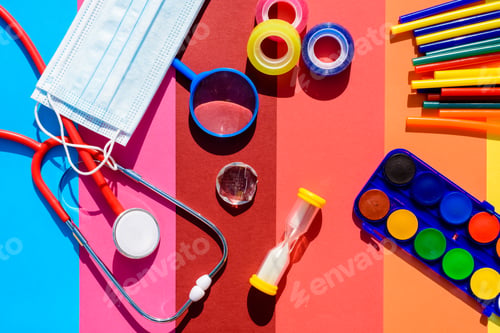Preview: School supplies and protective mask during classes on a colorful and cheerful background.