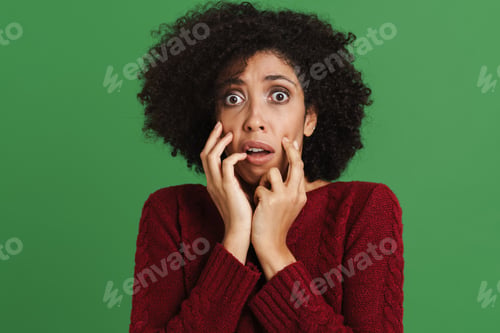 Preview: Black young woman wearing sweater expressing surprise at camera