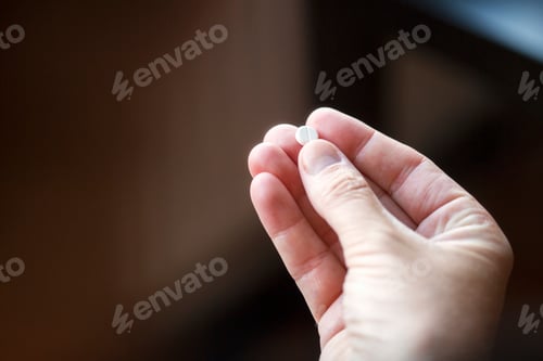 Preview: Close-up of hand holding pill