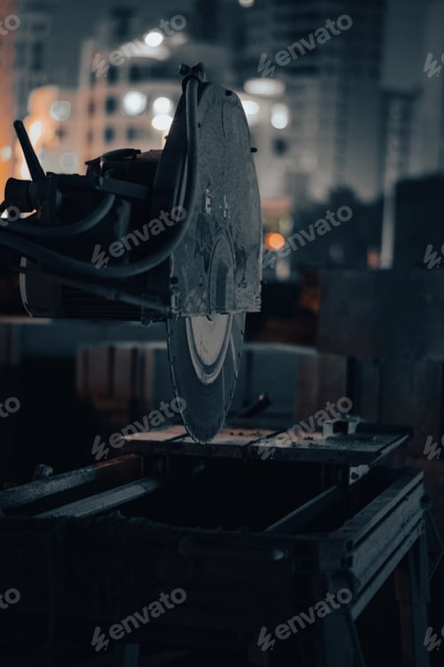 Preview: Close-up a cutting tool to shape a piece of metal in a factory at night
