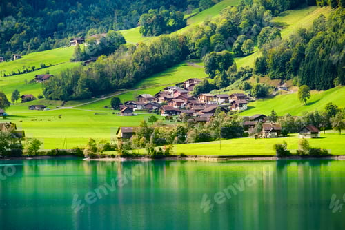 Preview: Lungern, canton of Obwalden, Switzerland. A view of rural homes in a green meadow.