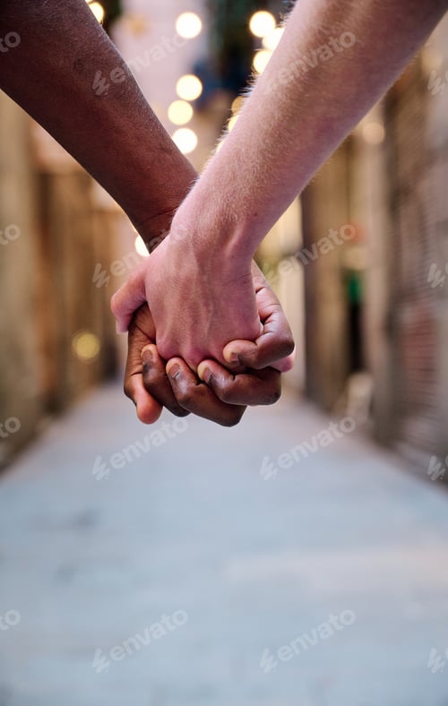 Preview: interracial love couple holding hands in outdoor location - multiethnic concept