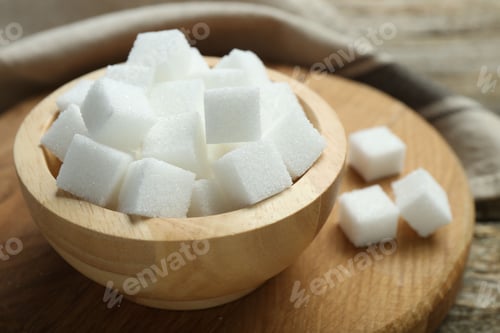 Preview: White sugar cubes in bowl on wooden board, closeup