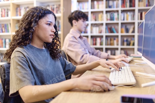 Preview: Teen girl using computer in school library