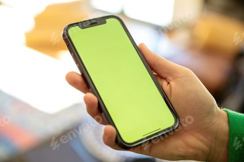 Preview: Hand hold mobile phone with blank screen. Smartphone empty display on a male hand, close up