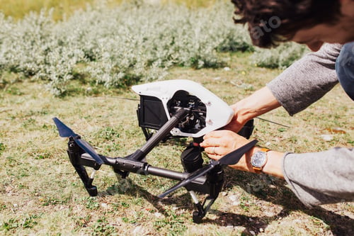 Preview: Man adjusting drone on field