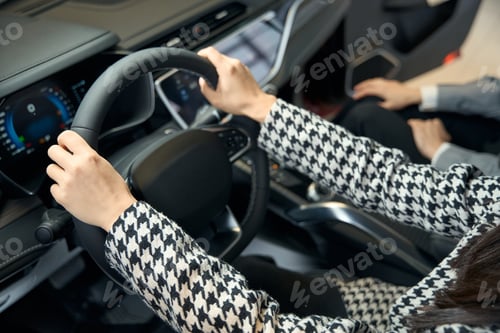 Preview: Female hands in a jacket on the steering wheel