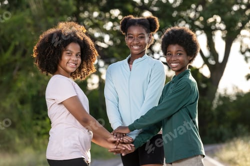 Preview: African curly hair teenagermaking a stack of hands.