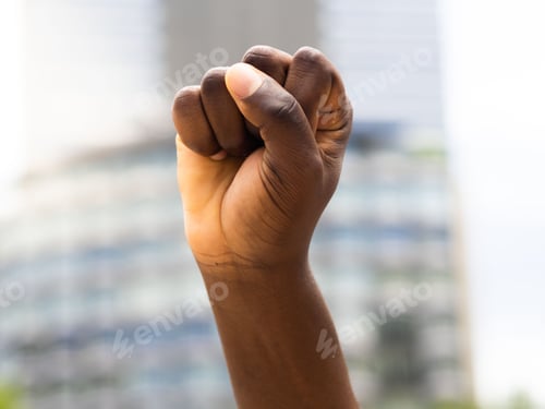 Preview: Closeup of human hand making a fist isolated in blurred background