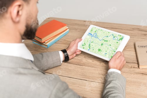 Preview: cropped view of businessman using digital tablet with map on screen isolated on grey
