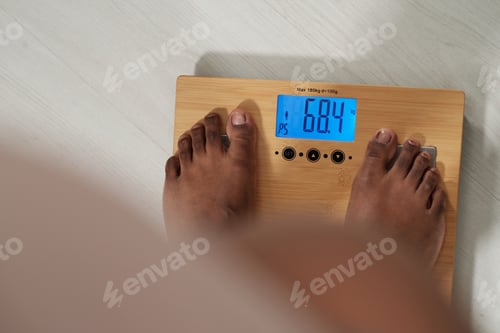 Preview: Feet of barefoor woman standing on scales