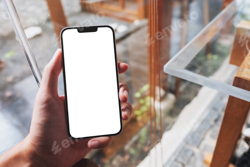 Preview: Mockup image of a man holding mobile phone with blank white screen in cafe