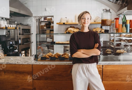 Preview: Portrait of smiling young woman entrepreneur standing at the counter of her bakery and coffee shop