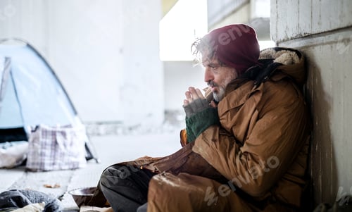 Preview: Homeless beggar man sitting outdoors in city asking for money donation.