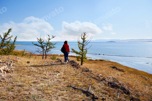 Preview: A woman with a backpack travels on Lake Baikal on a sunny day.