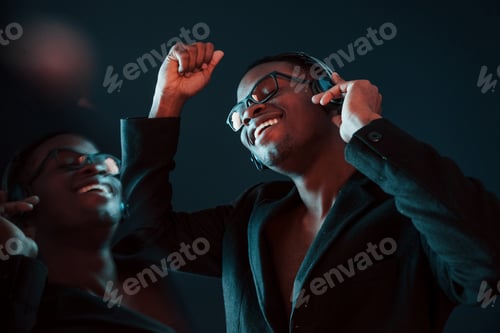Preview: In glasses. Futuristic neon lighting. Young african american man in the studio
