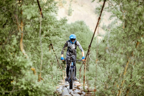 Preview: Cyclist riding on the old bridge in the mountains