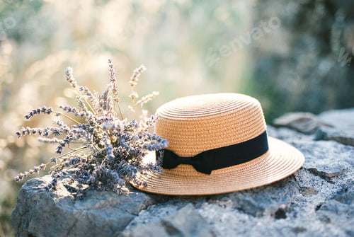 Preview: Lavender bouquet next to a straw hat on stones