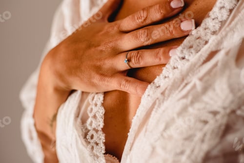 Preview: Wedding ring in the hands of a woman with her wedding dress.