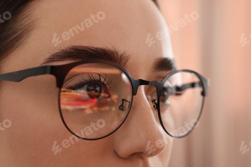 Preview: Woman wearing glasses on blurred background, closeup
